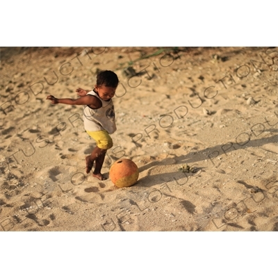 Small Boy Playing Football on a Beach on Gili Meno