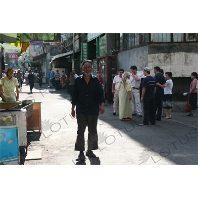 Uighur Man Walking Down a Street in Urumqi