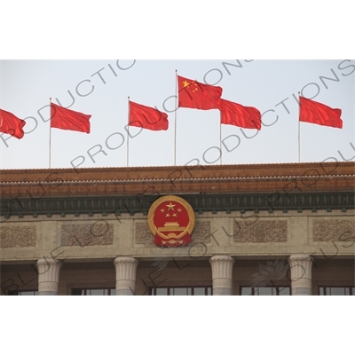 Communist Party Insignia and Chinese Flags on top of the Great Hall of the People (Renmin Dahuitang) in Tiananmen Square in Beijing