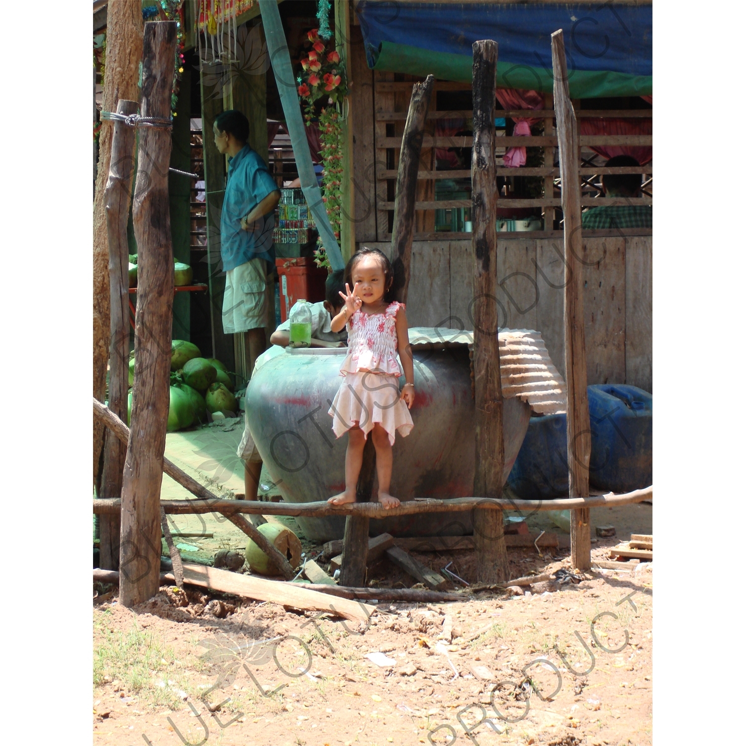 Cambodian Girl Holding up Three Fingers by the Side of a Road in Angkor