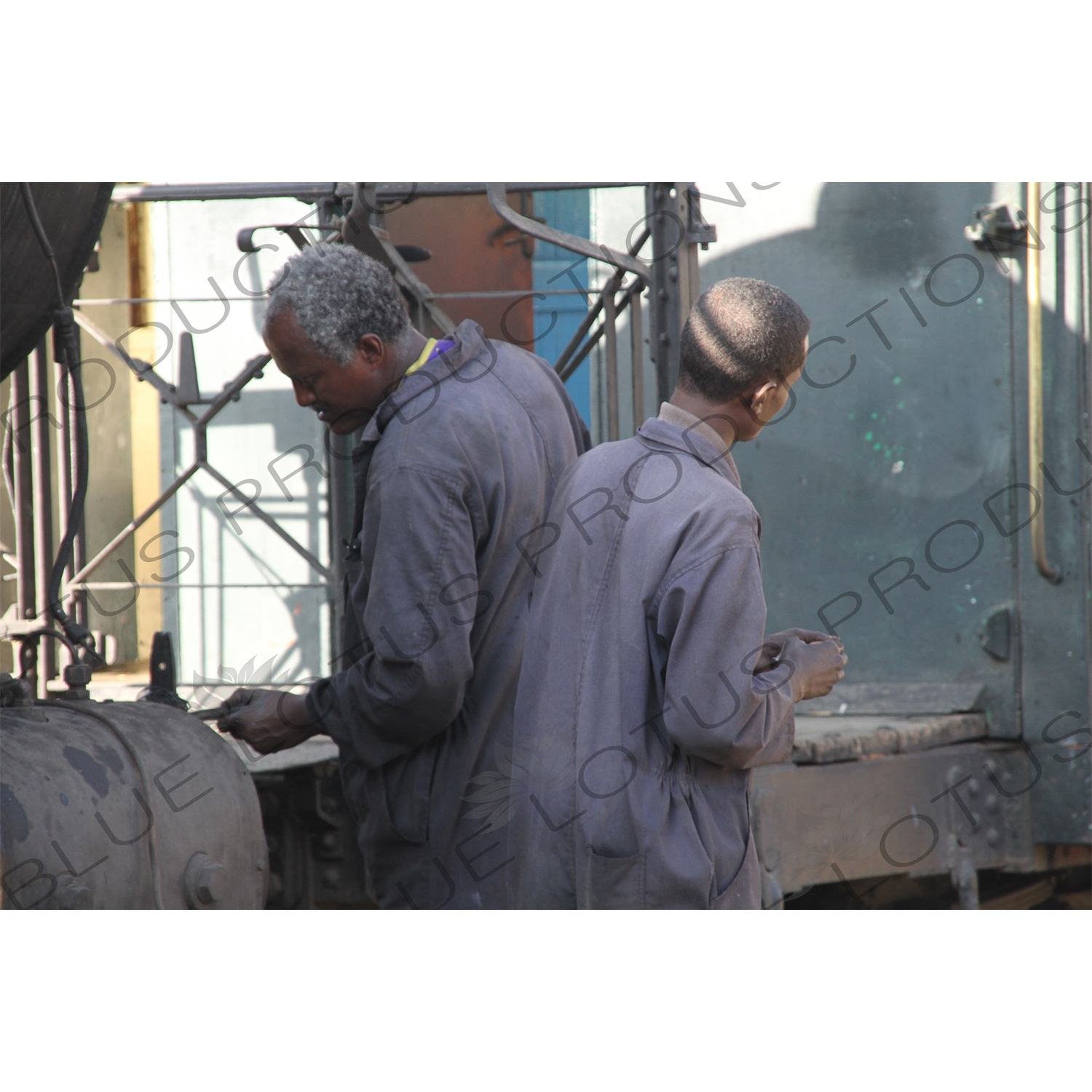 Driver and Engineer Inspecting a Vintage Steam Engine Going from Asmara to Massawa