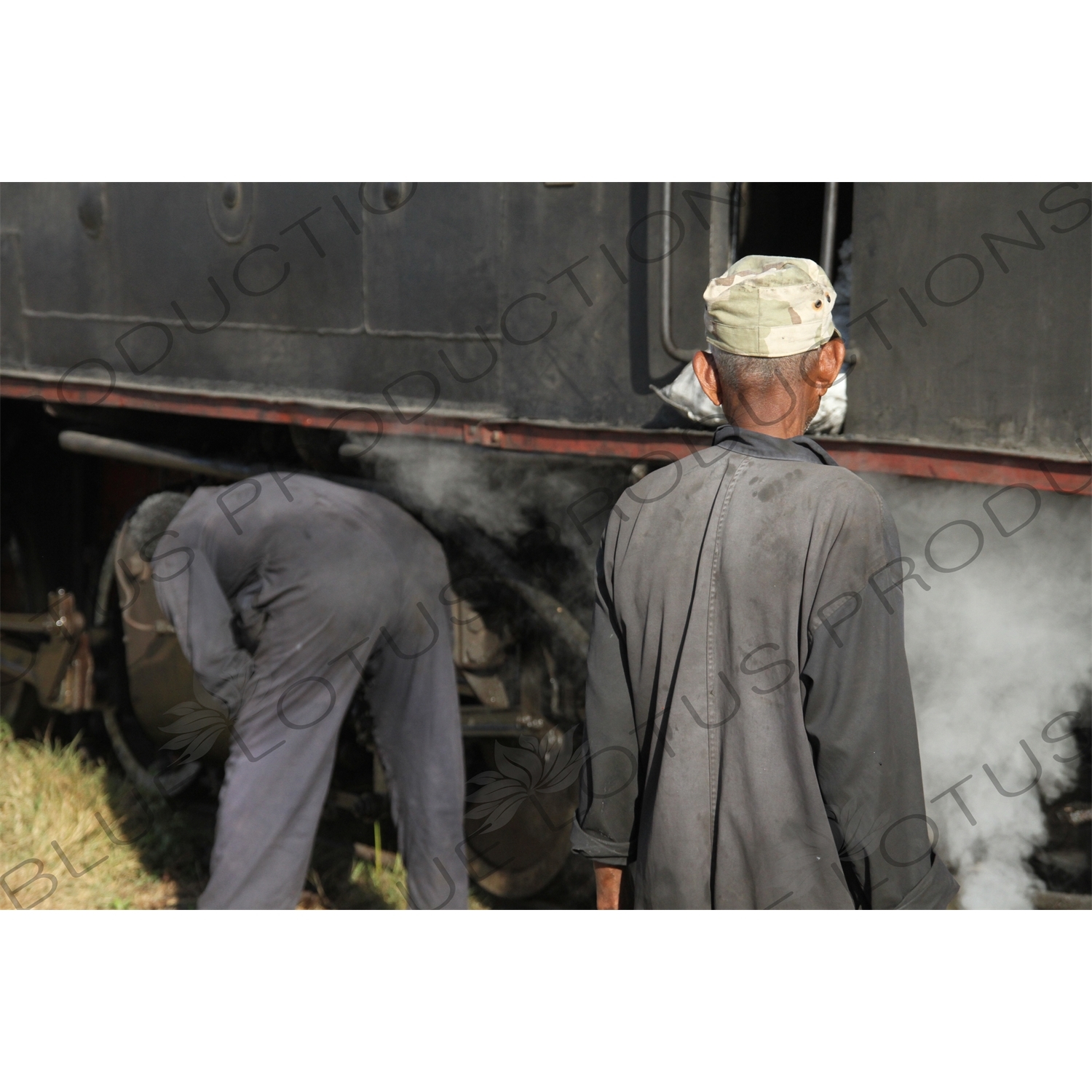 Driver and Engineer Inspecting a Vintage Steam Engine Going from Asmara to Massawa