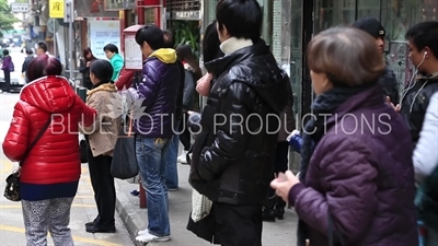 People Waiting at a Bus Stop in Macau