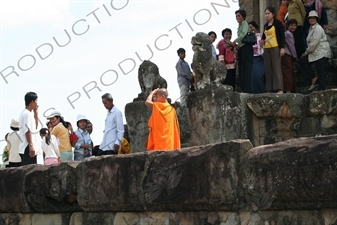 Buddhist Monks and Tourists on Terrace of Bakong in Angkor