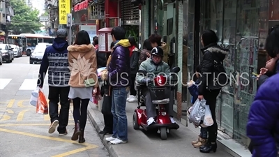 People Waiting at a Bus Stop in Macau