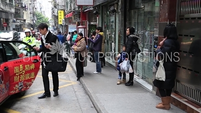 People Waiting at a Bus Stop in Macau