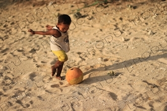 Small Boy Playing Football on a Beach on Gili Meno