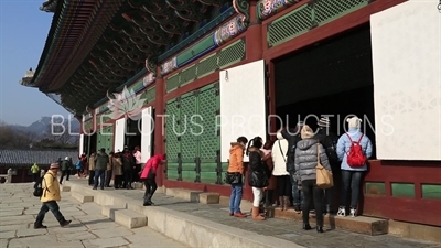 Tourists Looking inside Geunjeong Hall (Geunjeongjeon) at Gyeongbok Palace (Gyeongbokgung) in Seoul
