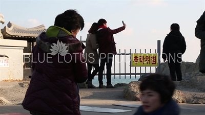 People Praying in front of Gold Buddha Statue at Haedong Yonggung Temple (Haedong Yonggungsa) in Busan