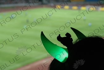 Beijing Guoan Fan's Flashing Green Horns during a Chinese Super League Match against Dalian Shide at the Workers' Stadium (Gongren Tiyuchang) in Beijing