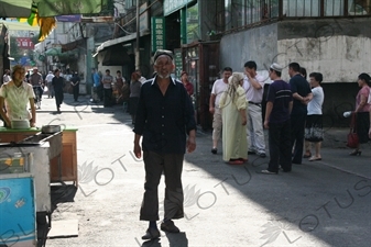 Uighur Man Walking Down a Street in Urumqi