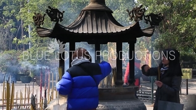 People Burning Incense in a Censer at Po Lin Monastery on Lantau Island