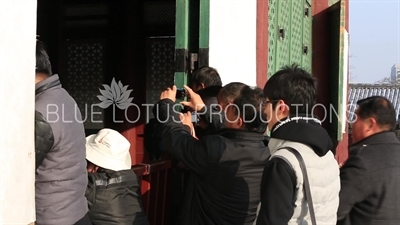 Tourists Taking Photos in the doorway of Geunjeong Hall (Geunjeongjeon) at Gyeongbok Palace (Gyeongbokgung) in Seoul