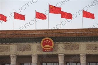 Communist Party Insignia and Chinese Flags on top of the Great Hall of the People (Renmin Dahuitang) in Tiananmen Square in Beijing