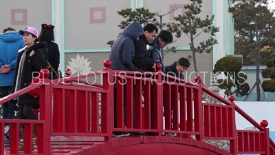 People on the Haeundae Sea and Wooden Bridge at Haedong Yonggung Temple (Haedong Yonggungsa) in Busan