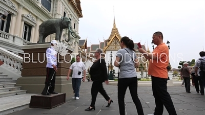 People Taking Pictures next to a Royal Guard at the Entrance of Phra Thinang Chakri Maha Prasat at the Grand Palace (Phra Borom Maha Ratcha Wang) in Bangkok