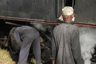 Driver and Engineer Inspecting a Vintage Steam Engine Going from Asmara to Massawa