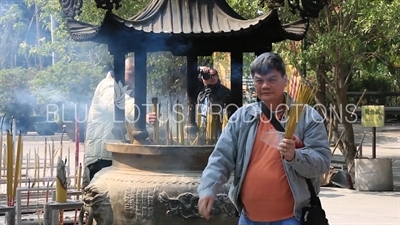 People Burning Incense in a Censer at Po Lin Monastery on Lantau Island